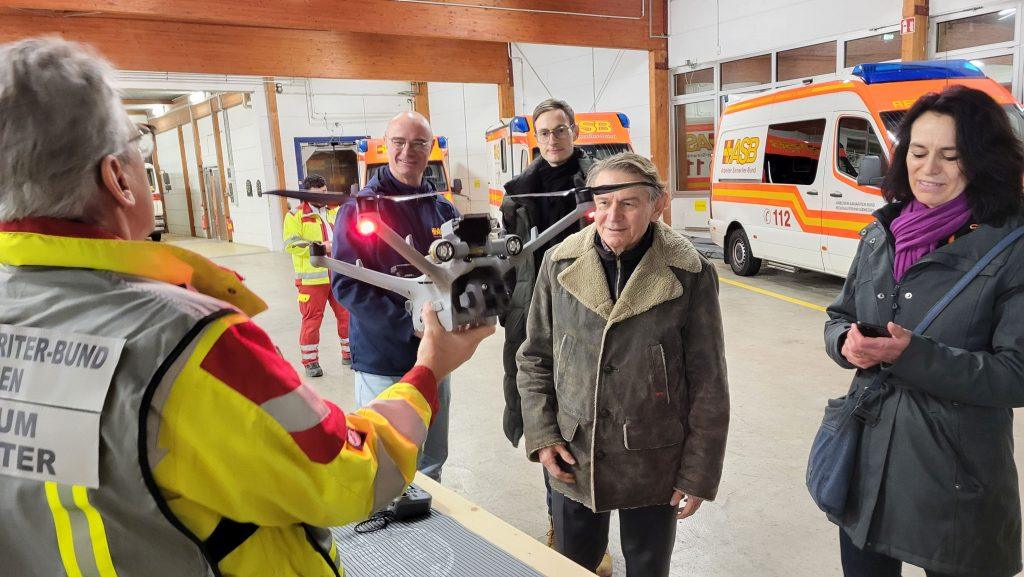 Der Vorstandsvorsitzende der Dotter-Stiftung, Karl Georg Dotter (Mitte), begutachtet im Beisein der Stiftungsreferentin Heidi Bittlingmaier die von Michael Dosch (1. v. links) vorgeführte neue Drohne der ASB-Drohnenstaffel. Über die Fördermittel der Dotter-Stiftung freuen sich auch der ASB-Geschäftsführer Günther Krupp (hinten links) und Manuel Wluka vom ASB-Fundraising (hinten rechts).