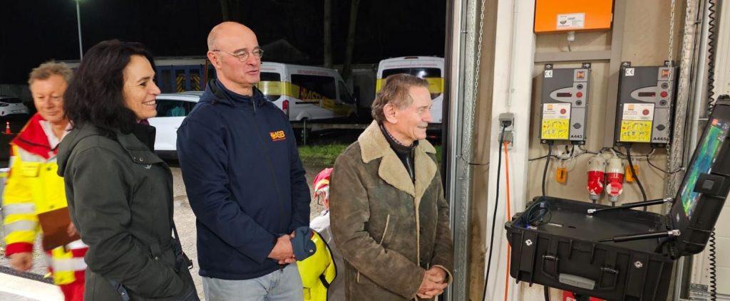 Bei einer simulierte Personensuche konnte der Drohneneinsatz mit Wärmebildkamera auf einem großen Monitor unten am Boden mitverfolgt werden (von links: Fernpilot Paul Huttarsch, Stiftungsreferentin Heidi Bittlingmaier, ASB-Geschäftsführer Günther Krupp und der Vorsitzende der Dotter-Stiftung Karl Georg Dotter).