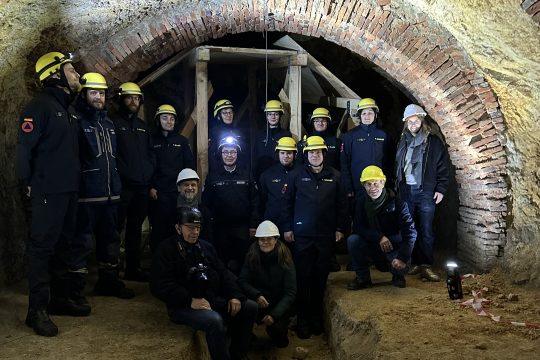 Volunteer helpers from the THW (Federal Agency for Technical Relief) Darmstadt local chapter, Eva Katsiris – owner of the Dieburger Straße beer garden (right, with white helmet), City Councillor Michael Kolmer (kneeling, bottom right), Mareike Göddel – Lower Monument Protection Authority (kneeling, bottom center), Olaf Köhler – Head of the Lower Monument Protection Authority (kneeling, bottom left, with white helmet), Nikolaus Heiss (bottom, with black helmet). Photo: City of Darmstadt