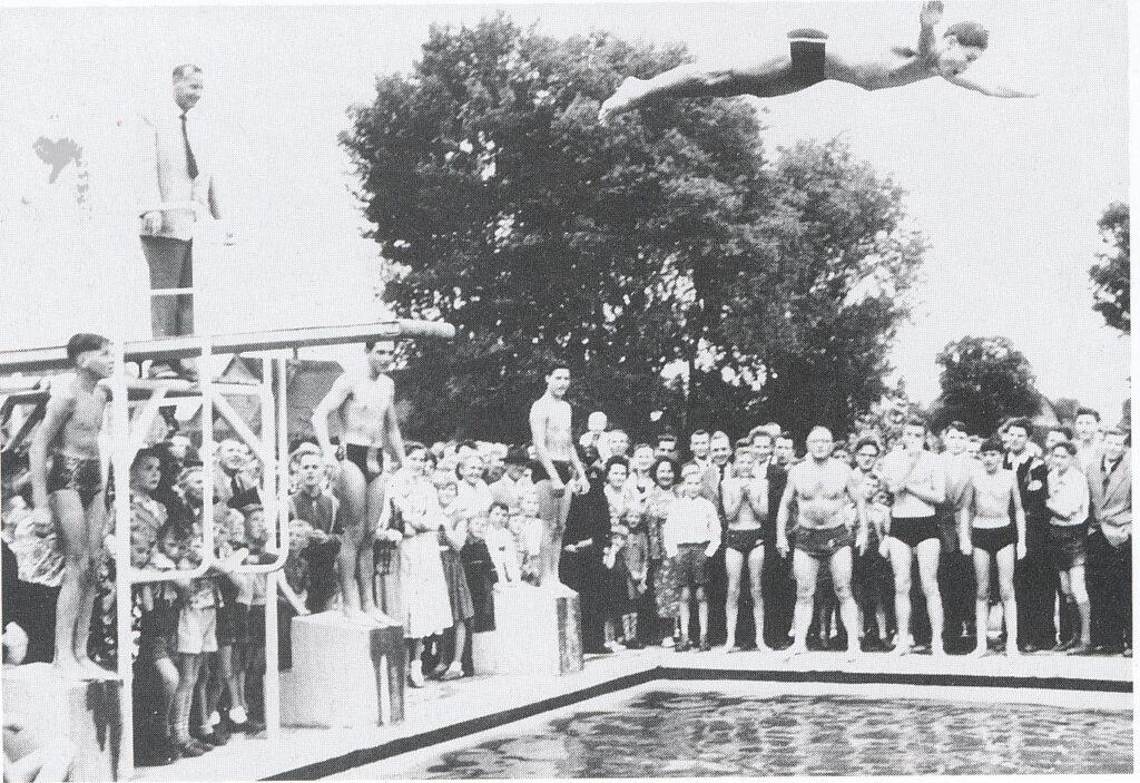 Mit einem Sprung ins Schwimmerbecken eröffnete Peter Bär 1956 das Freibad Goddelau. Hinter ihm steht sein Vater, Bürgermeister Christoph Bär. Foto aus: Georg Spengler, Goddelau wie es einmal war